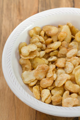 fried beans in white bowl on brown background