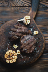 Grilled black angus beef steaks on a wooden chopping board