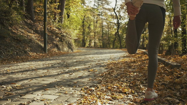 Young fitness woman runner stretching legs before run.