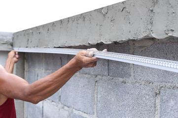 Asian man framing a wet concrete wall