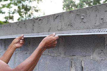 Asian man framing a wet concrete wall