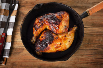 Roasted chicken legs on a cast iron skillet.