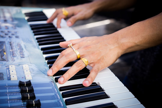 Pianist hand with ring on the electric piano