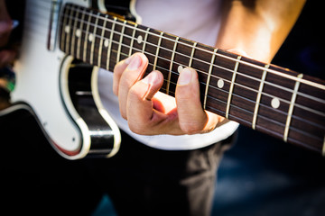Obraz na płótnie Canvas Hand of the Guitarist on electric guitar fingerboard