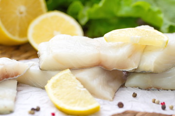 Raw fish with vegetables, lemon and seasonings on the wooden table