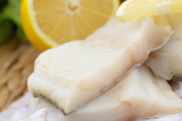 Fototapeta na wymiar Raw fish with vegetables, lemon and seasonings on the wooden table