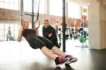 Tuinposter Personal trainer helping woman on her work out routines © Jacob Lund