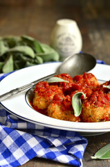 Homemade meatballs in tomato sauce with sage.