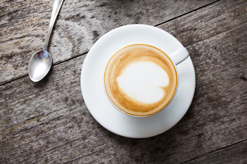 Cup of hot latte art coffee on wooden table,selective focus