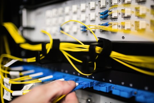 Technician inserting wire to server
