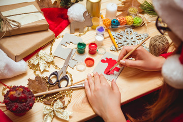 The girl at the table makes Christmas gifts. Hand made