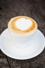 Cup of hot latte art coffee on wooden table,selective focus