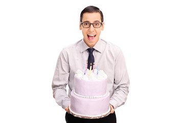 Cheerful young man holding a birthday cake