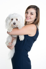 A studio image of a young woman,  with her white dog, huging it, both posing.