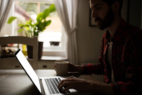 Man using his laptop in kitchen