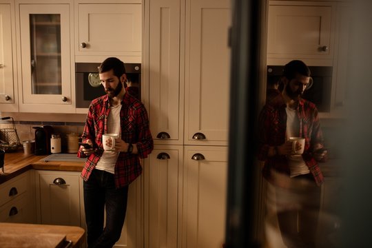 Handsome hipster relaxing in kitchen