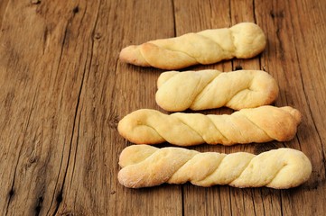 Homemade cheese twisted cookies on old wooden table