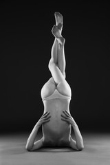 Naked yoga. Beautiful sexy body of young woman on gray background