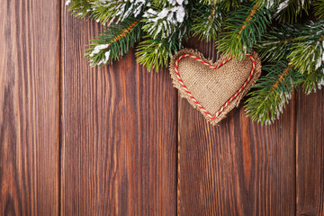 Fototapeta na wymiar Christmas tree branch with snow and heart toy