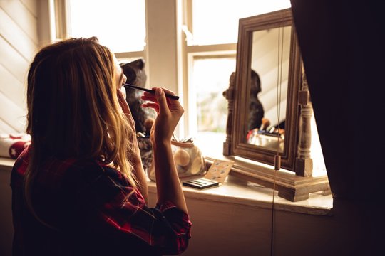 Woman making up herself in front of the mirror 