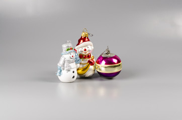 Christmas toy bear, ball and a snowman on a gray background