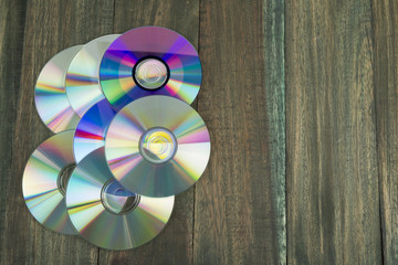 Discos compactos en fondo de madera r&uacute;stica.