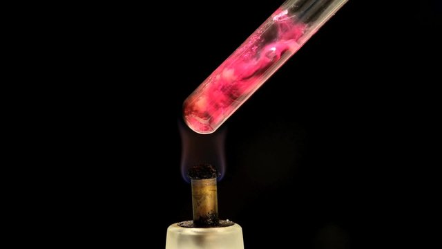 Close-up shot of boiling chemicals in a test tube on flame