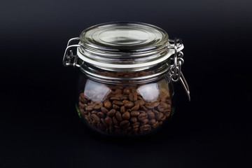 Coffee grains in glass jar on a black background