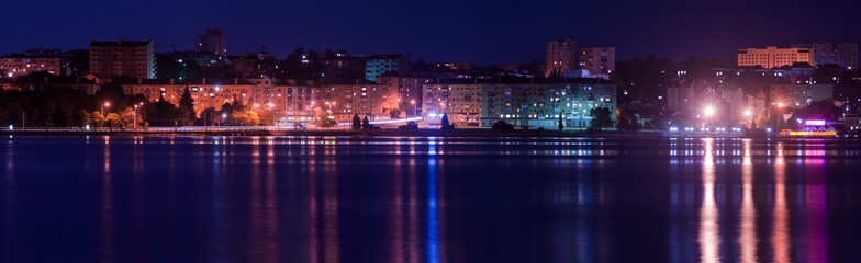 Fototapeta na wymiar Panorama night city with reflection in the water. Europe, Ukrain