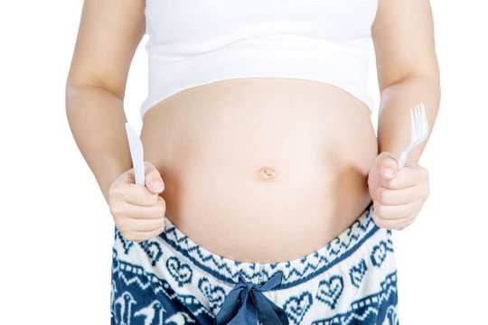 stomachs of pregnant woman with a fork and knife isolated on white