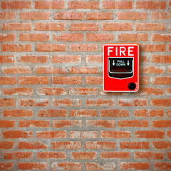 fire break glass alarm switch on brick wall background