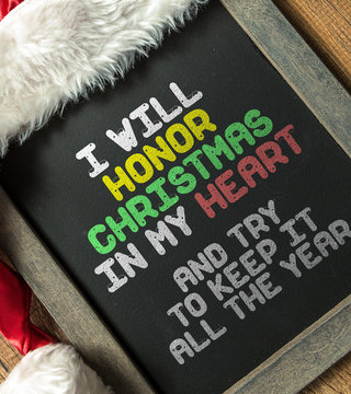 I Will Honor Christmas In My Heart And Try to Keep It All the Year written on blackboard with santa hat