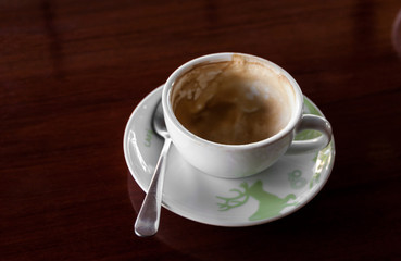 Cup of coffee with hot tea pot on wooden and blur background