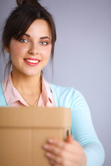Fototapeta premium Portrait of pretty woman holding a box 