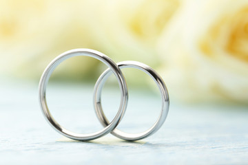 Silver wedding rings on a blue wooden table