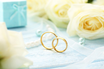 Golden wedding rings on a blue wooden table