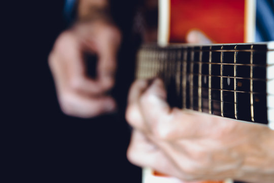 Blurred image of hands playing a guitar