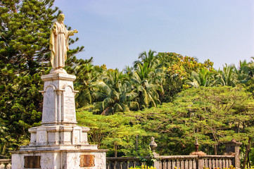 Statue of Jesus in Se Cathedral church around palm trees in Panaji, Old Goa, India - obrazy, fototapety, plakaty