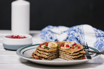 Stack of healthy low carbs oat pancakes over white wooden background