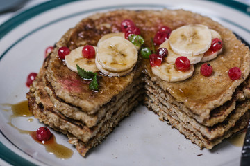 Stack of healthy low carbs oat pancakes over white wooden background