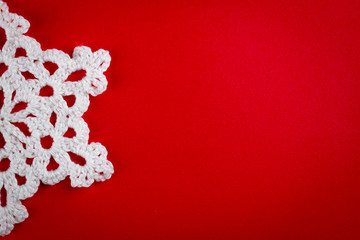 snowflakes crocheted from white thread on a red background