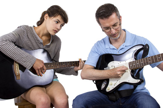 Female looking frustrated with male music instructor teaching how to play guitar