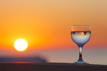 Glass of white vine with reflections of houses and view to beaut