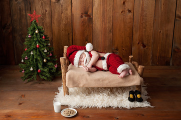 Sleeping Newborn Baby Boy Wearing a Santa Suit with Beard