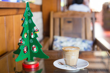 hot latte coffee and christmas tree on wooden table