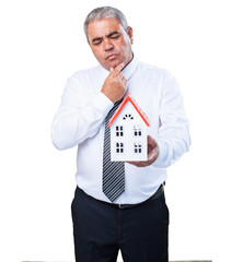 worried mature man holding a house