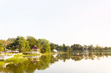 Obraz premium outdoor public park view in evening with pavilion beside the pon