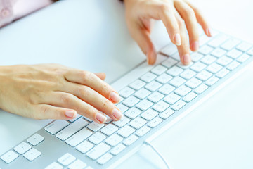 Woman office worker typing on the keyboard