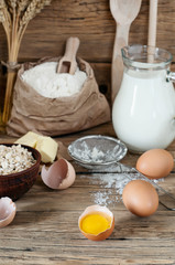 Half raw eggs with ingredients for making bakery products