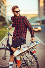 Naklejka premium Man in sunglasses riding a bike on city street